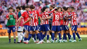 Atletico scored twice in the second half to beat its city rival, which played a man down nearly