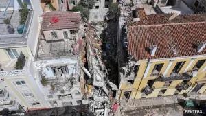 Rescuers combing through the rubble of a building that collapsed in a blast in the Greek