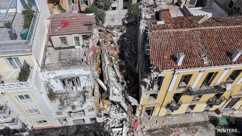 Rescuers combing through the rubble of a building that collapsed in a blast in the Greek