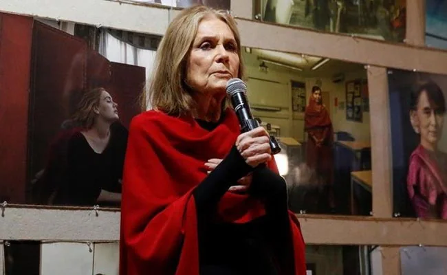 With her trademark streaked hair parted down the middle and large aviator glasses, Steinem