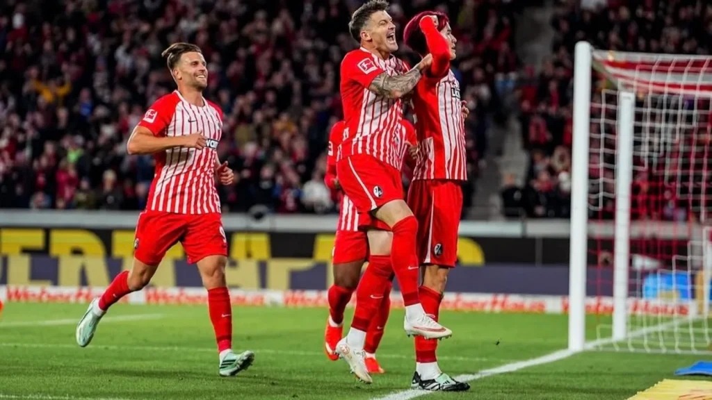 Japan forward Keisuke Goto's late header fired ten-man Freiburg to the top of the German